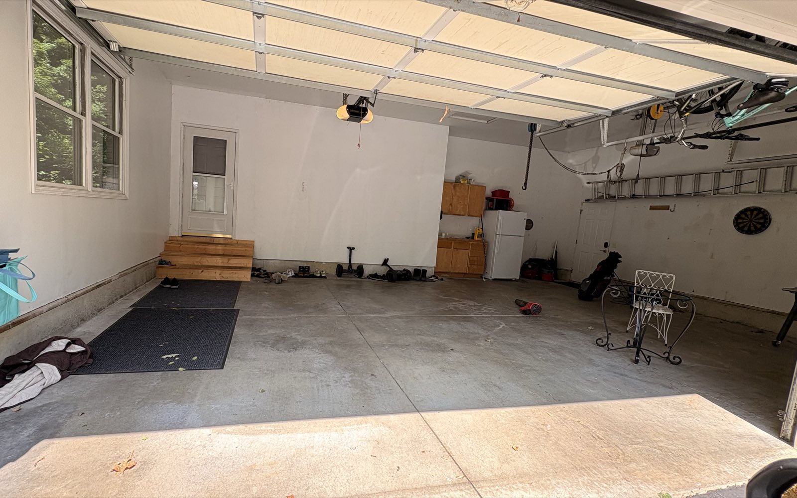 Three-car garage in Tipton, Michigan before the pour: a bare, stained concrete slab with a cracked control joint.